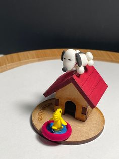 a small toy dog on top of a wooden house