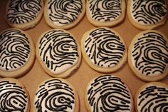 cookies decorated with black and white icing are arranged on a cookie sheet in rows