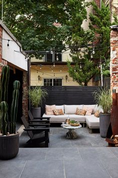 an outdoor living area with couches, tables and cacti on the patio