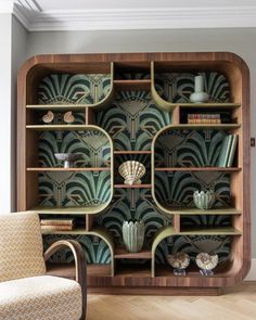 an art deco bookcase with books and vases on it