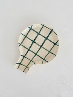 a white and green plate with lines on it's side, against a white background