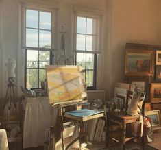 an artist's studio with easel and paintings