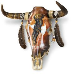 an animal skull with long horns and feathers on it's head is shown in this image