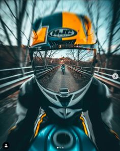 a person riding a motorcycle on a road with trees in the background