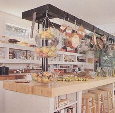 a kitchen filled with lots of pots and pans on top of a wooden counter