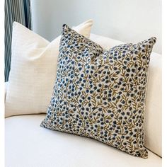 two pillows sitting on top of a white couch