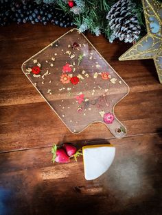 a cookie sheet with flowers on it next to some strawberries and pineconi