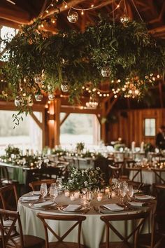 tables are set with candles and greenery for an elegant wedding reception at the barn