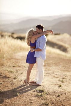 a man and woman embracing each other in the desert