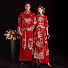 two people dressed in red and gold standing next to each other