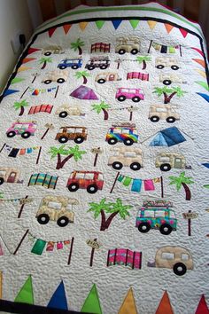 a quilted bed with cars and palm trees on it