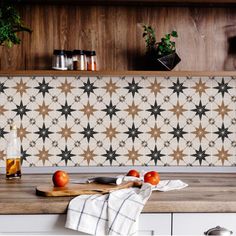 some tomatoes are on a cutting board in front of a wall with wooden shelves and potted plants