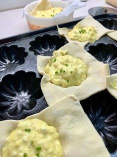 some food is sitting on top of a black tray and ready to be cooked in the oven