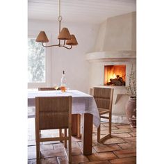 a dining room table and chairs with a fireplace in the background