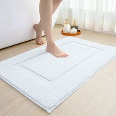 a person standing on top of a bath mat