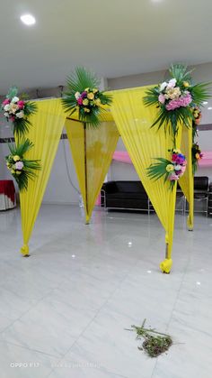 a yellow canopy decorated with flowers and greenery