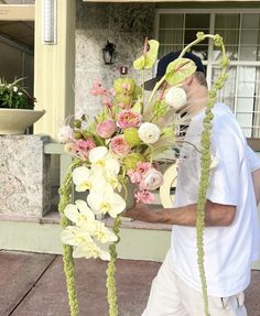 a man walking down the street with flowers in front of him