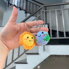 two crocheted keychains in the shape of animals with faces on them