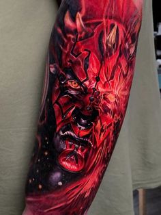 a man's arm with an evil demon tattoo on it