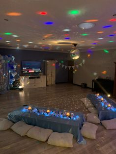 a party room with blue linens and balloons on the floor, lights in the ceiling