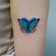 a blue butterfly tattoo on the arm