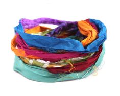 multicolored scarves stacked on top of each other with thread in the middle