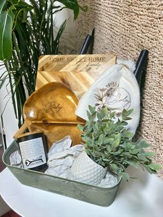 an assortment of items sitting on top of a white table next to a potted plant