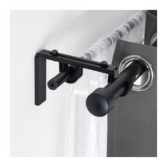 the curtain rod has two black handles on it and is next to a white curtain