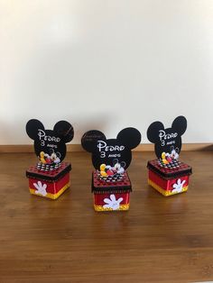 three mickey mouse cake boxes on a wooden table