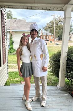 a man and woman are dressed up in costumes on the front porch of a house