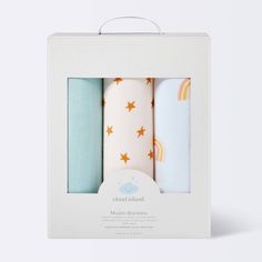 three baby swaddles in a white box with gold stars and rainbows on them