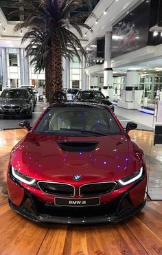 a red car is parked in a showroom