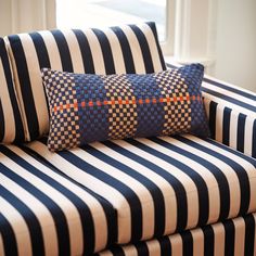 a black and white striped couch with two pillows on it's armrests