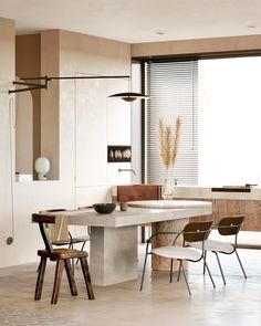 a modern kitchen with an island table and chairs