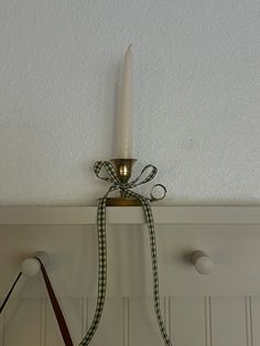 a candle is hanging on the wall next to two purses