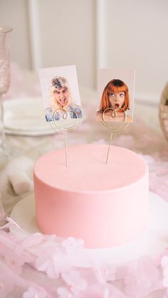 there is a pink cake with two pictures on the top and one has a woman's face