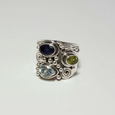 Ornate Sterling Silver Ring With Swirl And Bead Designs Around Genuine Peridot, Blue Topaz, And Iolite Stones. The Band Tappers From 18 Mm To 8 Mm. Funky Jewelry Rings, Rosé Core, Funky Rings, Iolite Stone, Pretty Jewelry, Cabochon Ring, Funky Jewelry, Class Ideas, Funky Nails