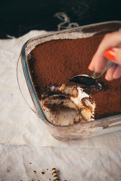 someone is scooping some cake into a glass dish