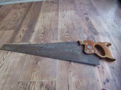 a pair of scissors sitting on top of a wooden floor next to a knife blade