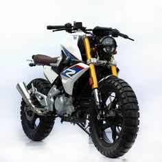 a white and blue motorcycle parked on top of a snow covered ground in front of a white background