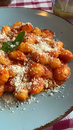 a white plate topped with pasta covered in sauce and parmesan sprinkles