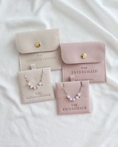 three bridesmaid jewelry sets are laying on a white sheet, one is pink and the other is gold