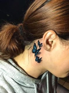 a woman with a blue butterfly tattoo on her left side of her neck and behind her ear