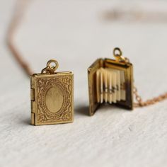 This exquisitely detailed little locket is a miniature book made from solid brass which has darkened over time to a rich gold colour.  Inside is a secret hidden message, specially folded and fitted inside the locket to look just like the pages of a real book! The locket has a perfectly working hinge and clasp and, if you wish, there is space inside for you to add two tiny photos.  The locket is a lovely and delicate size, measuring just 16mm x 10mm (about the size of a thumbnail).  The necklace Book Locket Necklace, Engraved Locket, Silk Purse, Personalized Book, Book Locket, Gold Engraving, Proposal Gifts, Bookish Gifts, Personalized Books