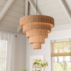 a dining room table and chairs under a large light fixture in a white walled room