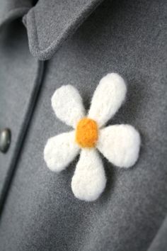 a white flower is placed on the lapel of a gray suit jacket with buttons