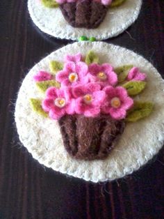 two crocheted coasters with flowers on them