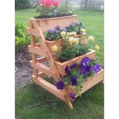 three tiered wooden planter filled with flowers