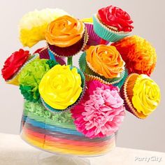 cupcakes with colorful icing are in a vase