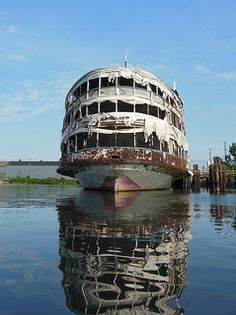 an old boat sitting on top of a body of water